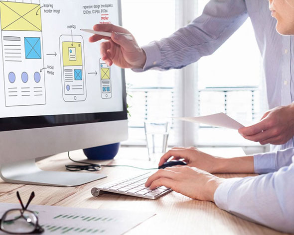 Website designer instructs his colleague on the desktop screen